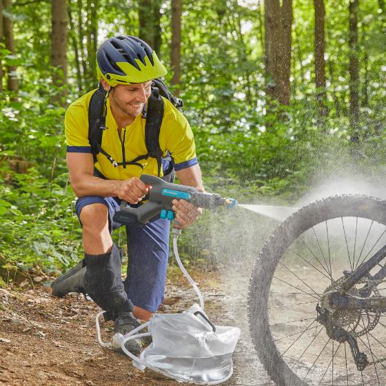 A man cleaning his bike with a battery medium pressure cleaner
